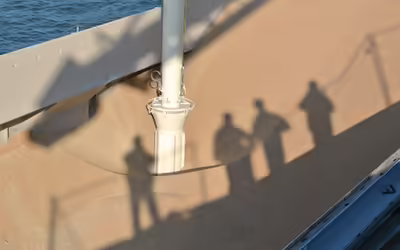 Die Schatten von vier Menschen fallen auf Schüttgut, dass von einem NEUERO Entlader aufgenommen wird.