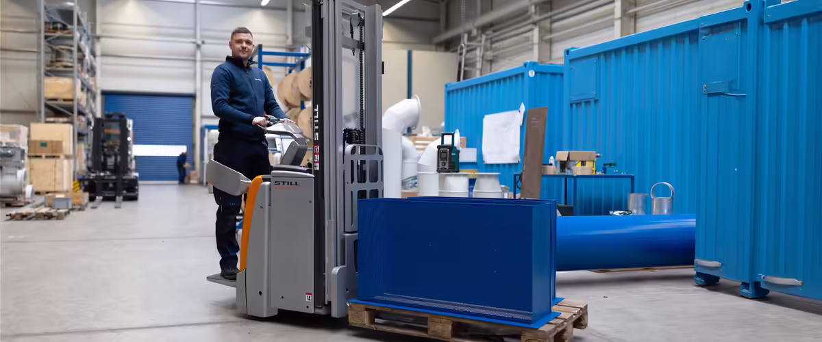 NEUERO Mitarbeiter Mathis Tüngel transportiert Maschinenteile mit einem Gabelstapler.