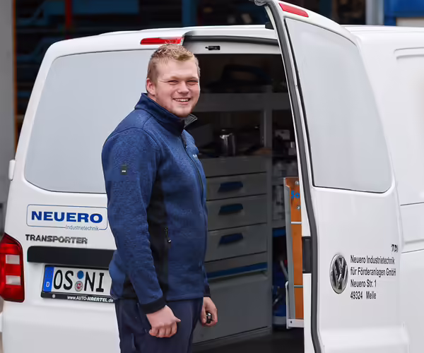 Ein NEUERO Mitarbeiter steht vor einem geöffneten Lieferwagen.