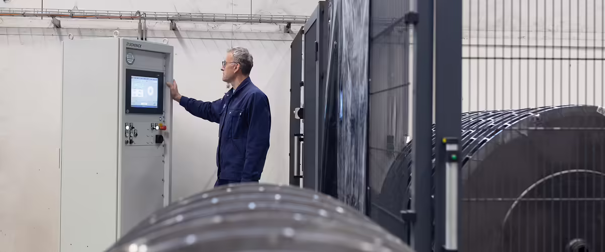 NEUERO Mitarbeiter Hermann Riemann kontrolliert einen Maschinenbildschirm.