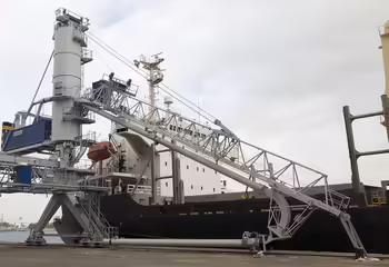 Ein abgelegter Auslegearm eines NEUERO Schiffsentladers an einer Hafenkante.